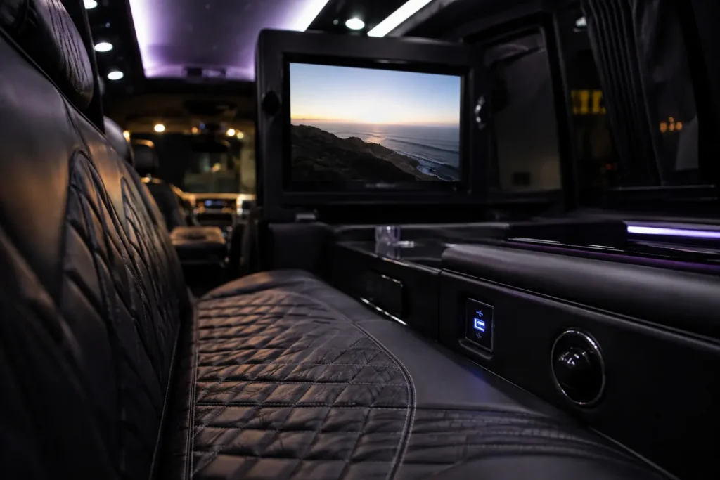 Limousine interior in Fairfield showing entertainment screen, charging port, and leather seating